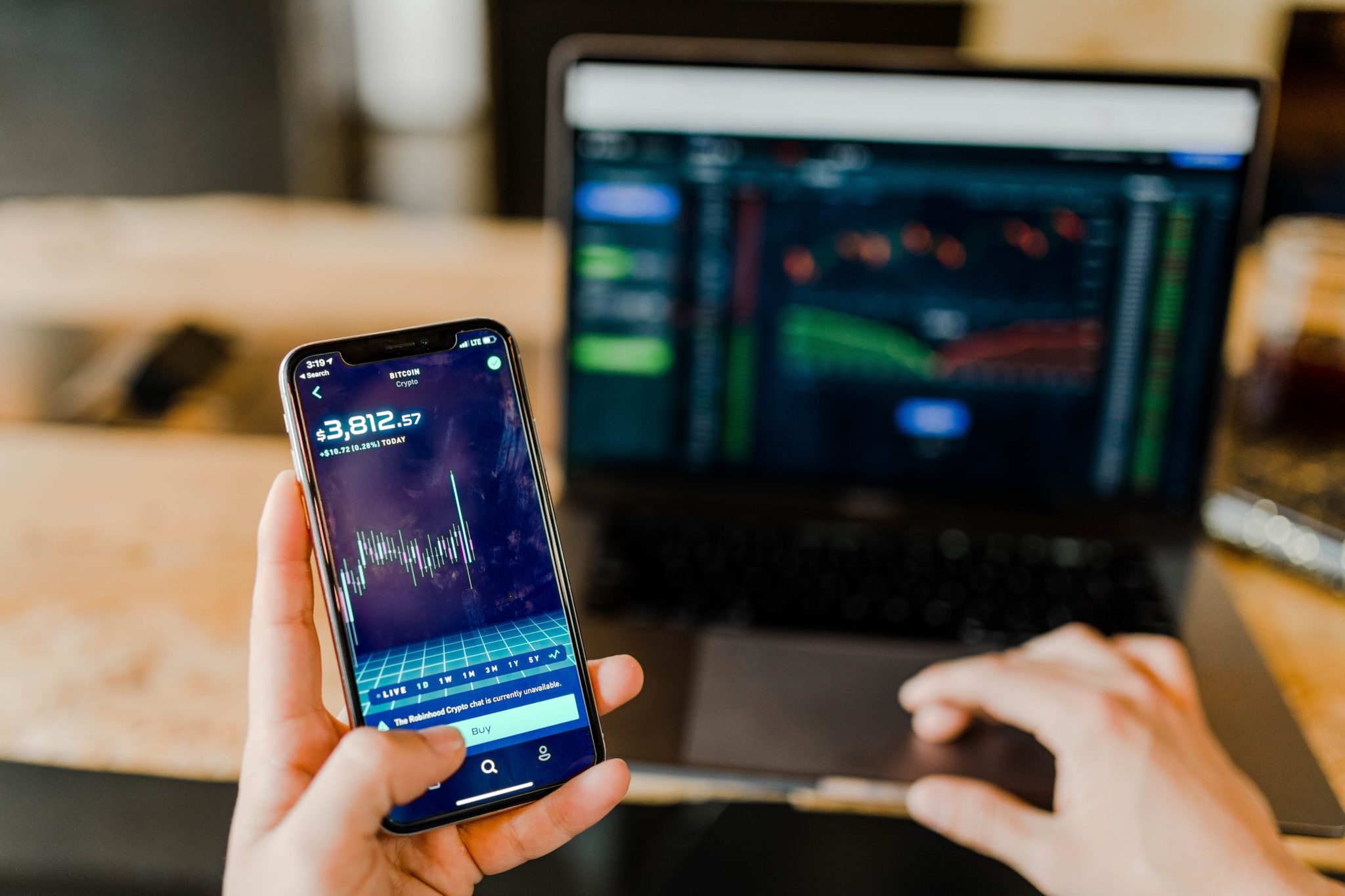 Person holding mobile phone while stock trading