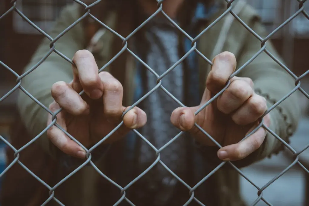 Man gripping a fence